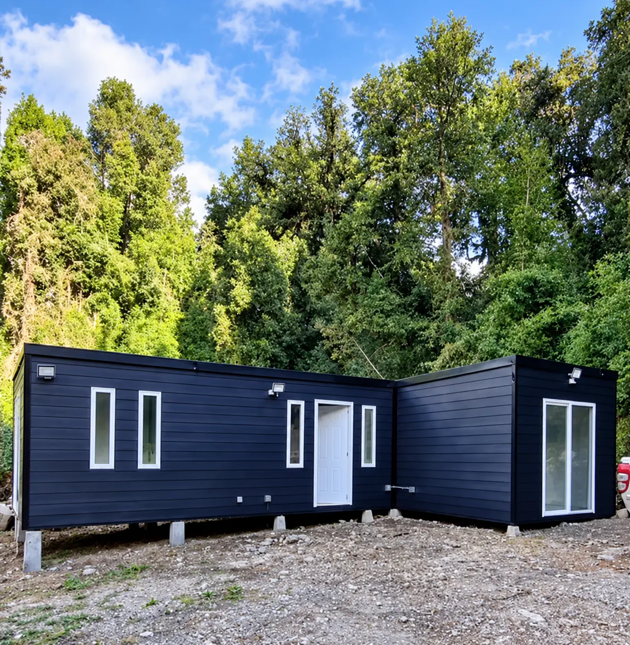 Casa modular azul instalada entre árboles nativos del sur de Chile