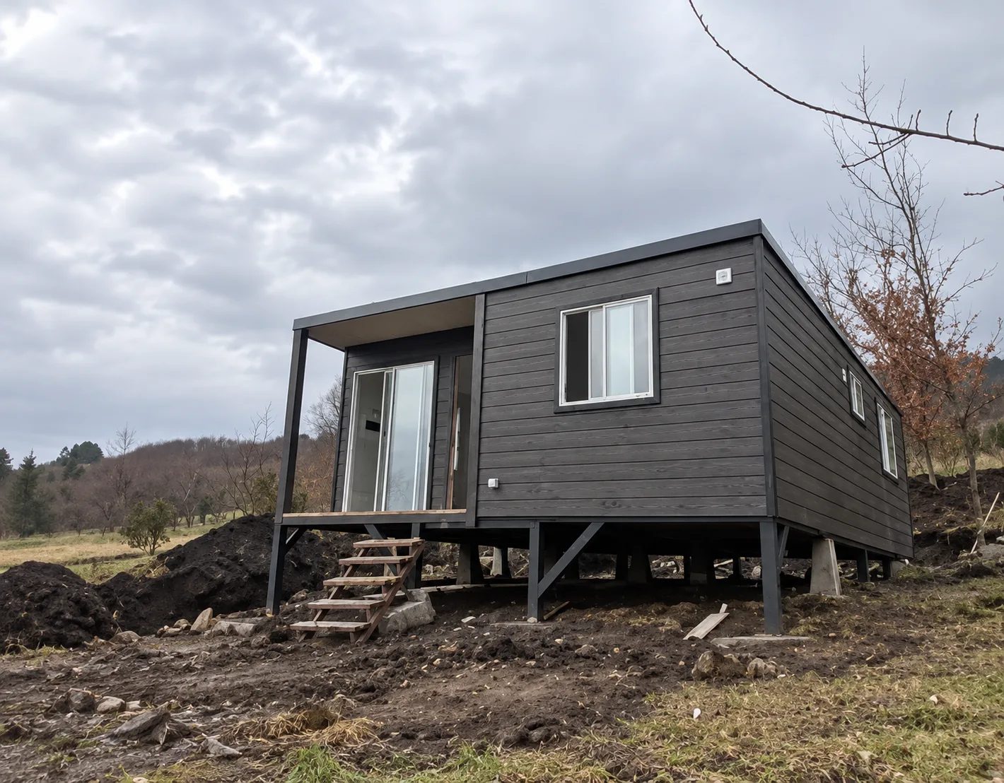 Casa modular gris en ladera nublada